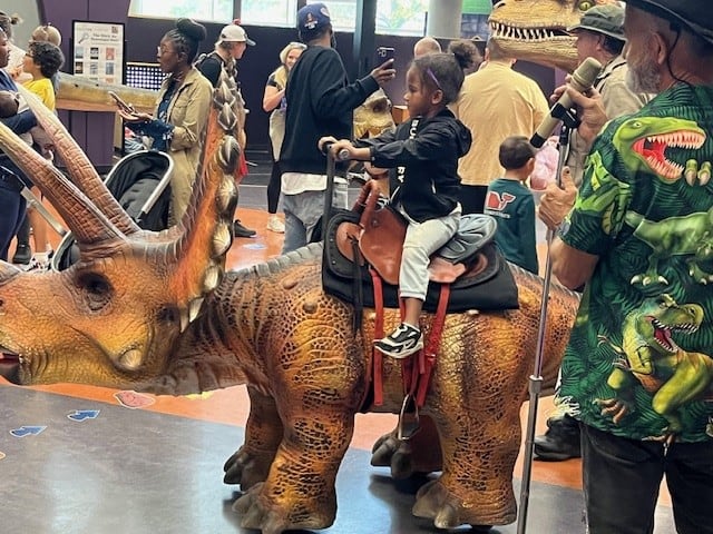 child riding a dinosaur