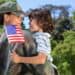 soldier holding young son, with flag