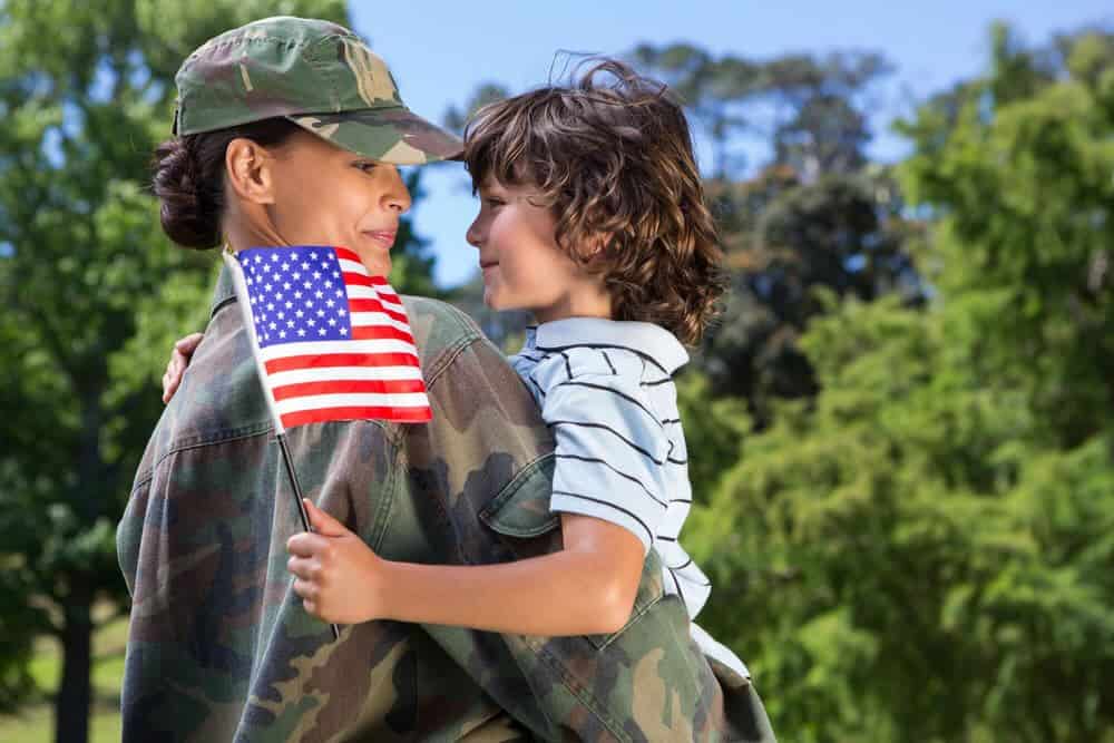 soldier holding young son, with flag