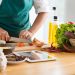chef in green apron cutting food with a knife