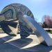 embrace sculpture with brightly colored mosaic, a disck and arches