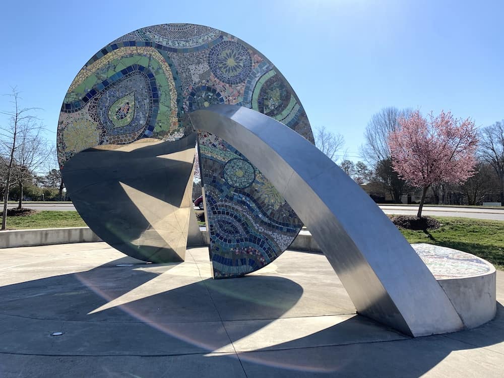 embrace sculpture with brightly colored mosaic