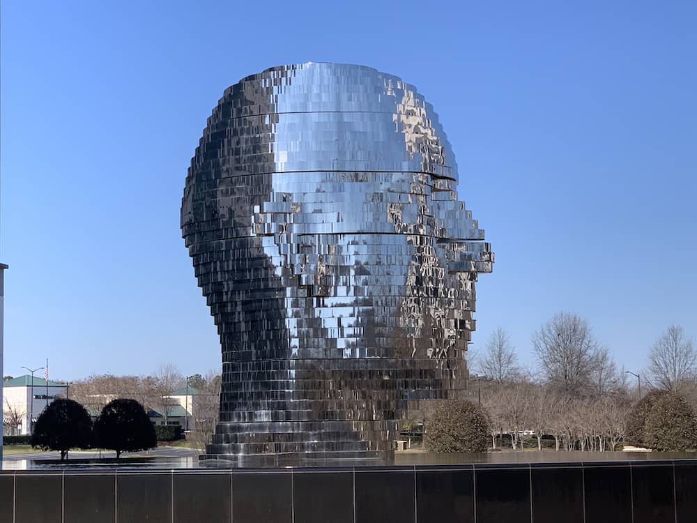 metalmorphosis a large reflective sculpture of a head