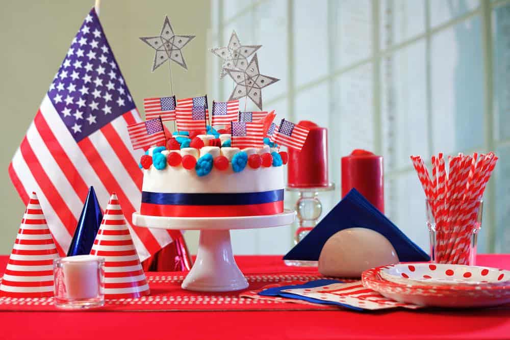 Red white and blue cake and flags on table