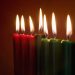 Seven Kwanzaa candles with flames lit on neutral background