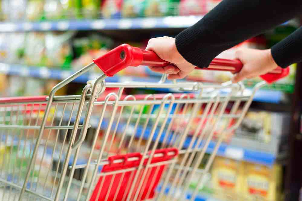 Closeup of hands pushing grocery cart at the supermarket