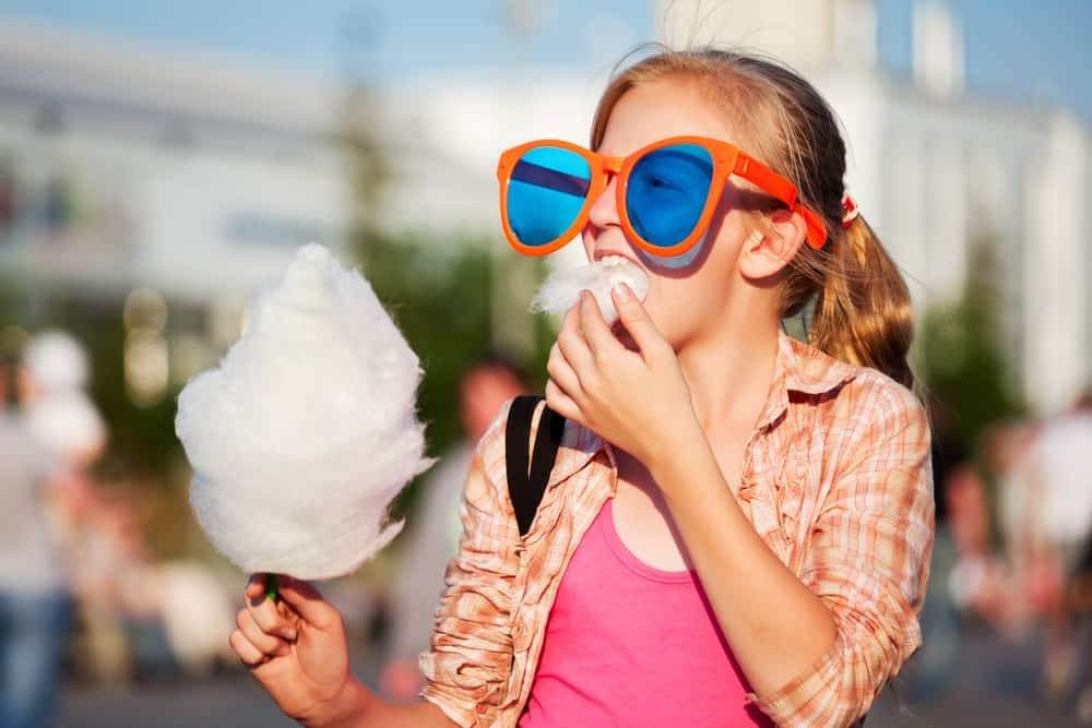 girl with big sunglasses eating cotton candy