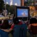 group of people watching movie outdoors at night