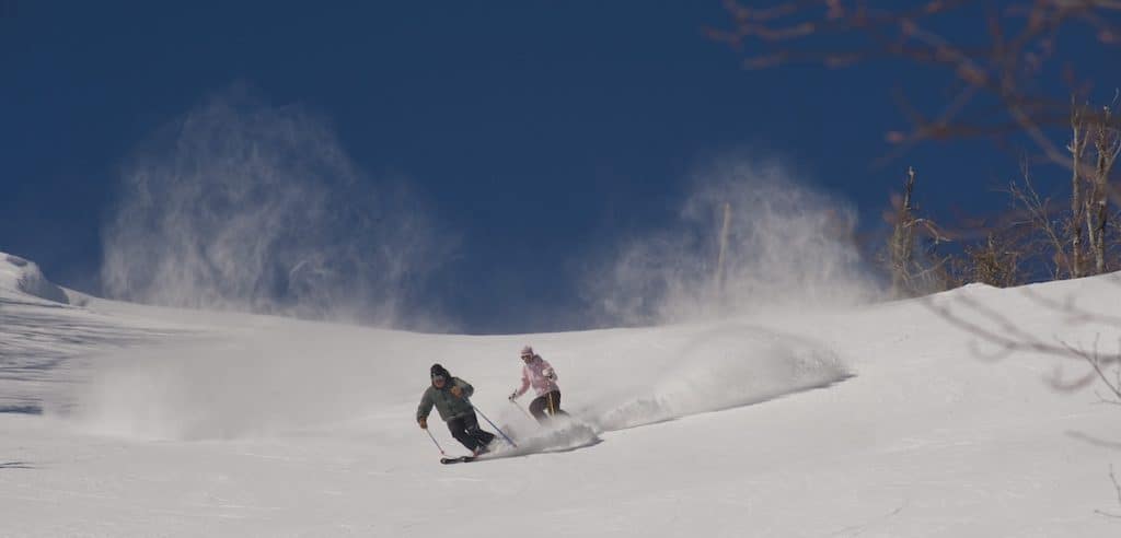 two people skiing down Sugar Mountain