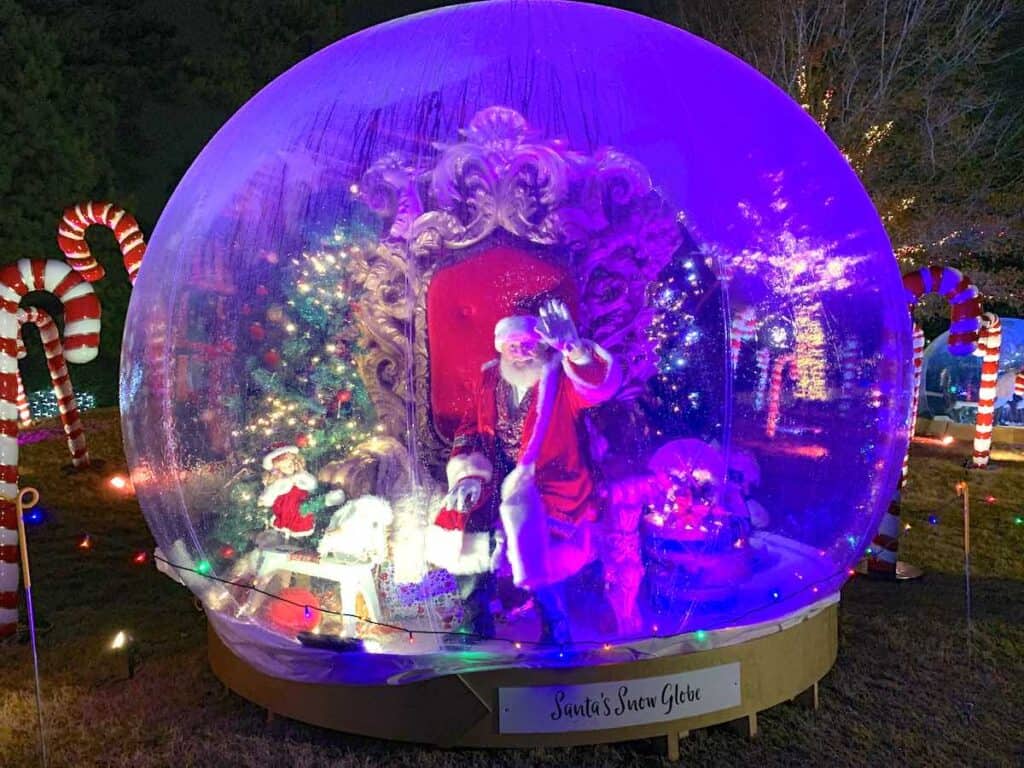 Santa waving from within a snow globe