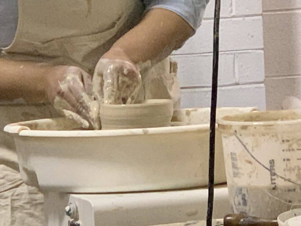 close-up of hands shaping clay on a pottery wheel at Makerspace Charlotte