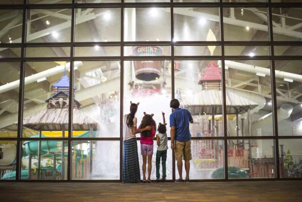 Family looking through a window into the Great Wolf Lodge water park