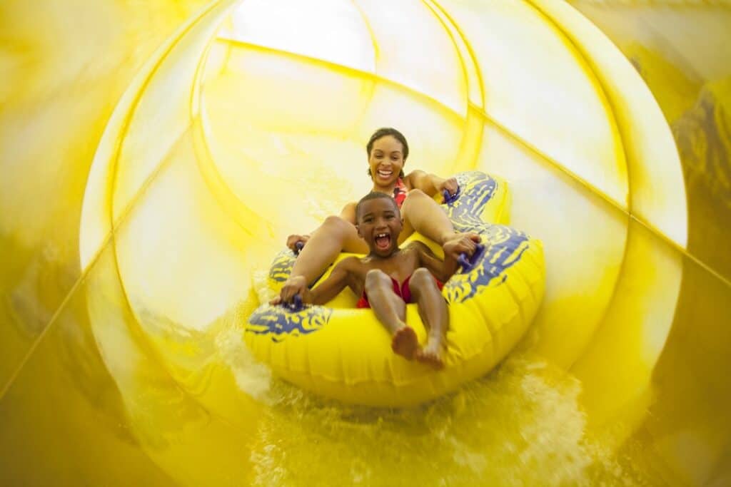 Woman and boy on a yellow water slide at Great Wolf Lodge