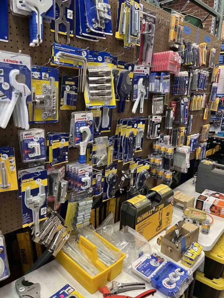Many new, packaged tools hanging on a pegboard for sale