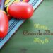 Happy Cinco de Mayo background with colorful maracas on Mexican theme dark green distressed table
