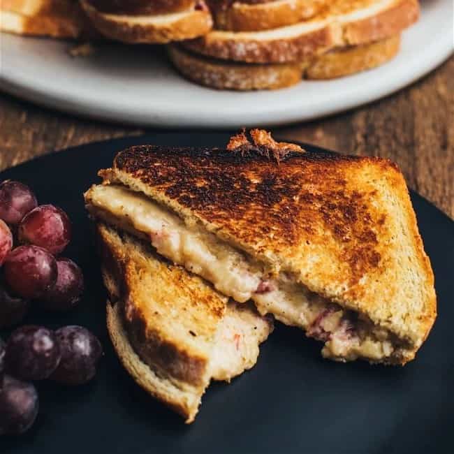 grilled cheese sandwich made with pimento cheese, and grapes, on a plate