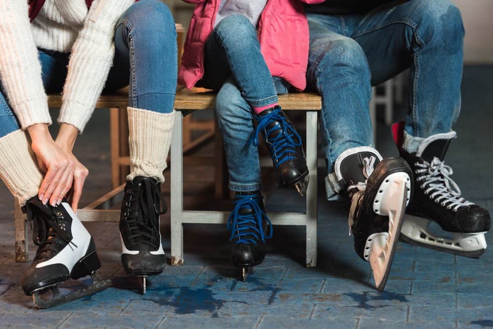 family putting on ice skates at a rink