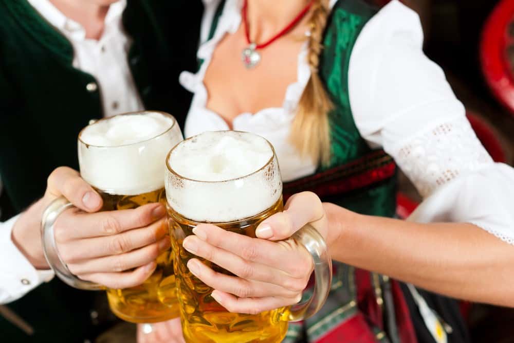 Couple in traditional German costumes holding beers