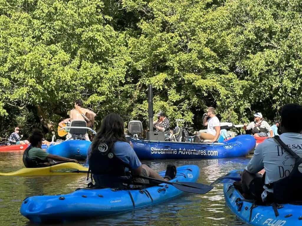 band floating down a river with people kayaking