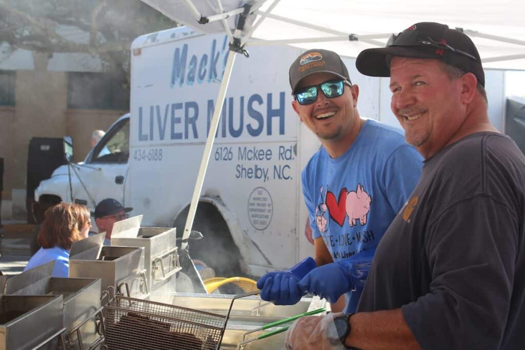 Two men cooking liver mush at festival
