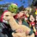 child holding alpaca, looking at the grinch