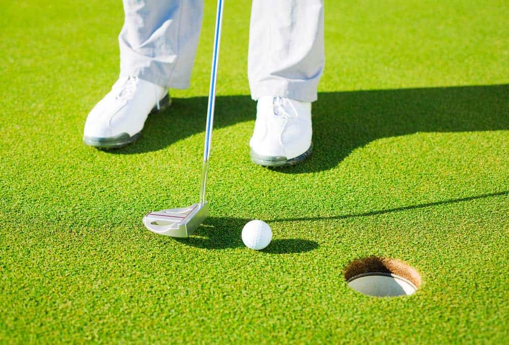 Putting Golf Ball into the Hole, Close up detail Shot