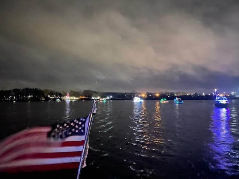 Lighted boat on lake with American flag in foreground