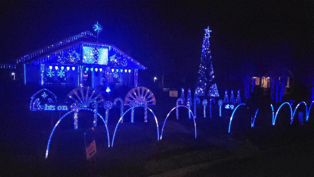 house and yard decorated in blue Christmas lights