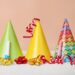 Colorful party hats, streamers and blowers on white table.