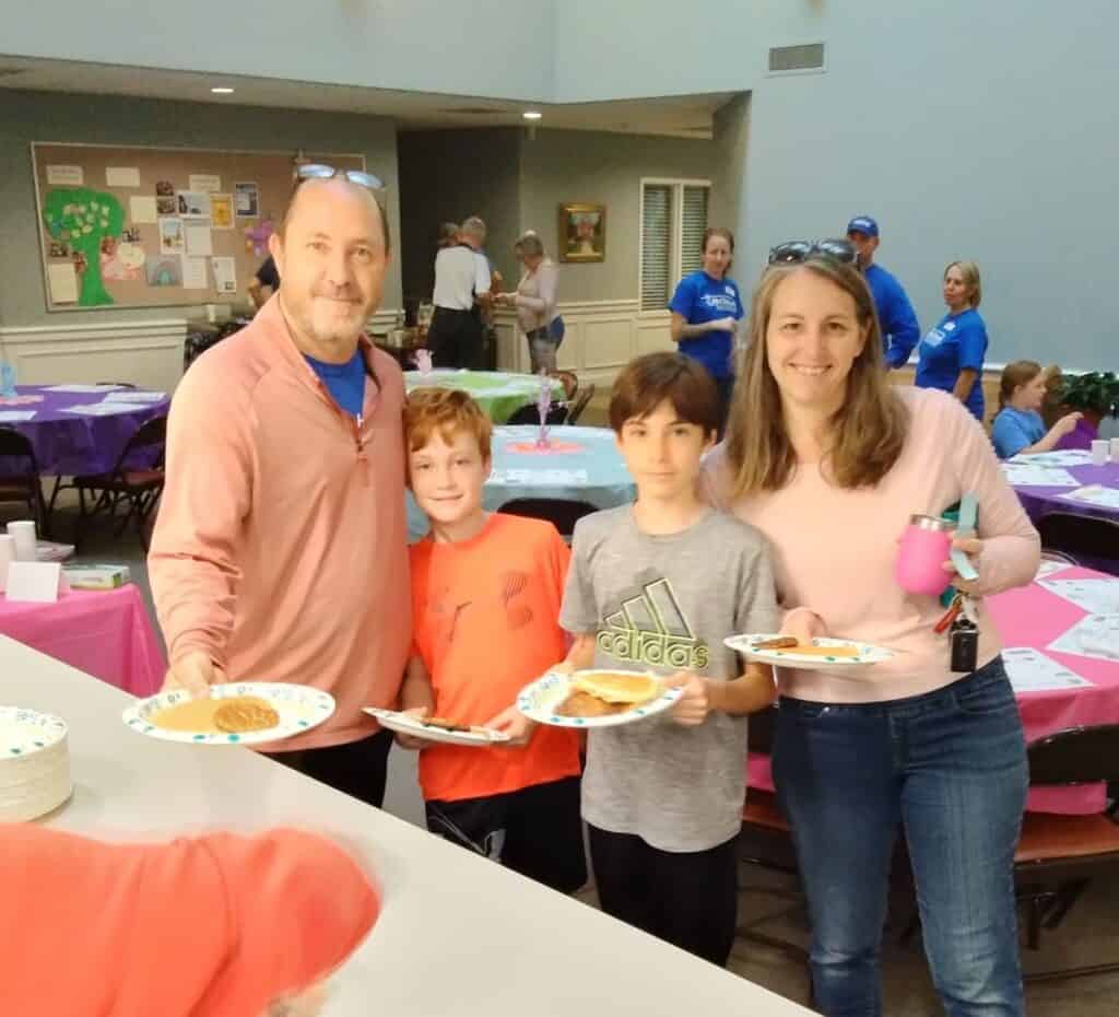 Family holding plates of pancakes