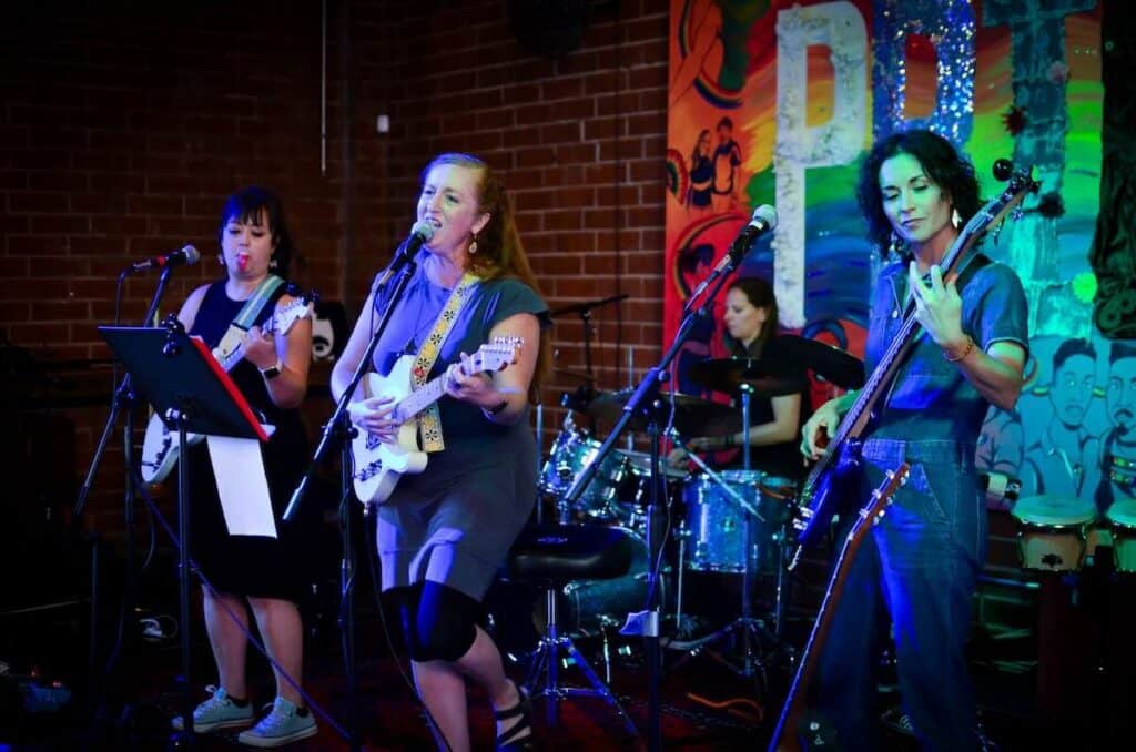 Four musicians playing instruments in a band