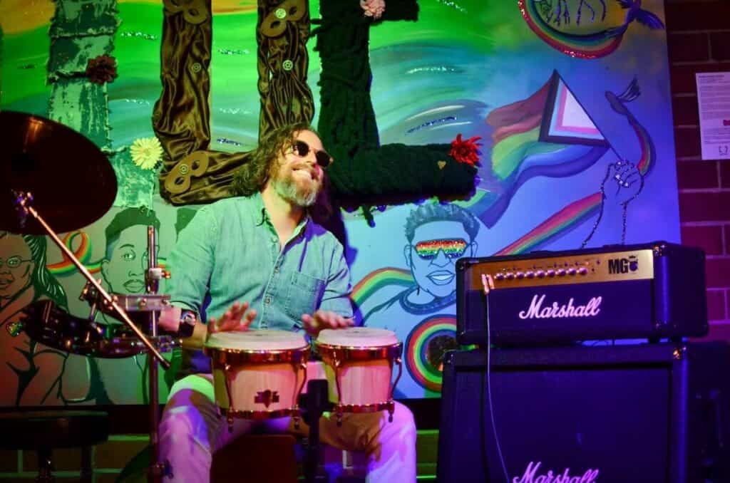 percussionist playing bongos and smiling
