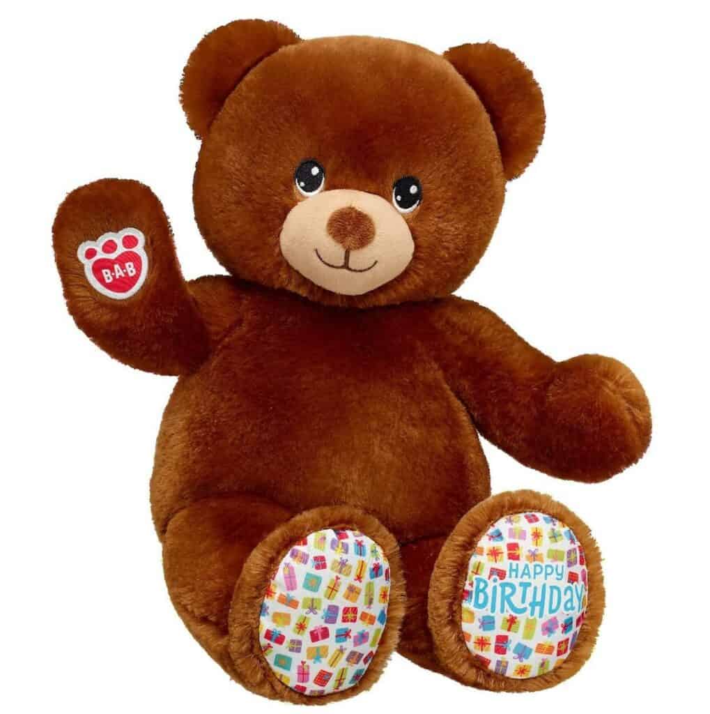 Brown teddy bear with happy birthday on foot