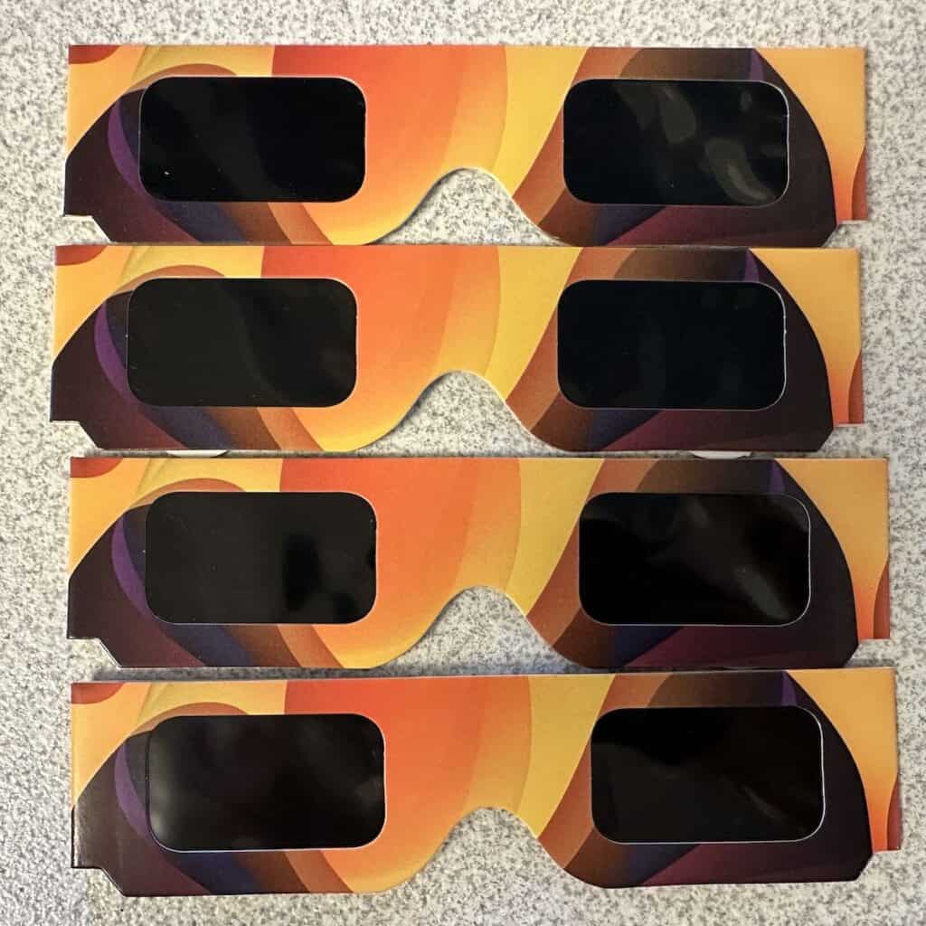 Four pairs of paper solar eclipse glasses for the April 8, 2024 solar eclipse