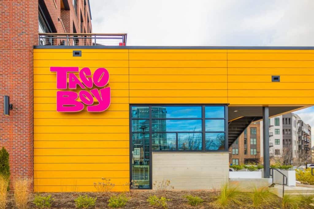 Yellow exterior of Taco Boy with pink letters