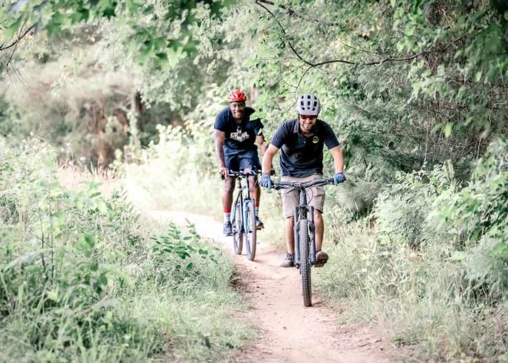 2 people riding bikes on a trail