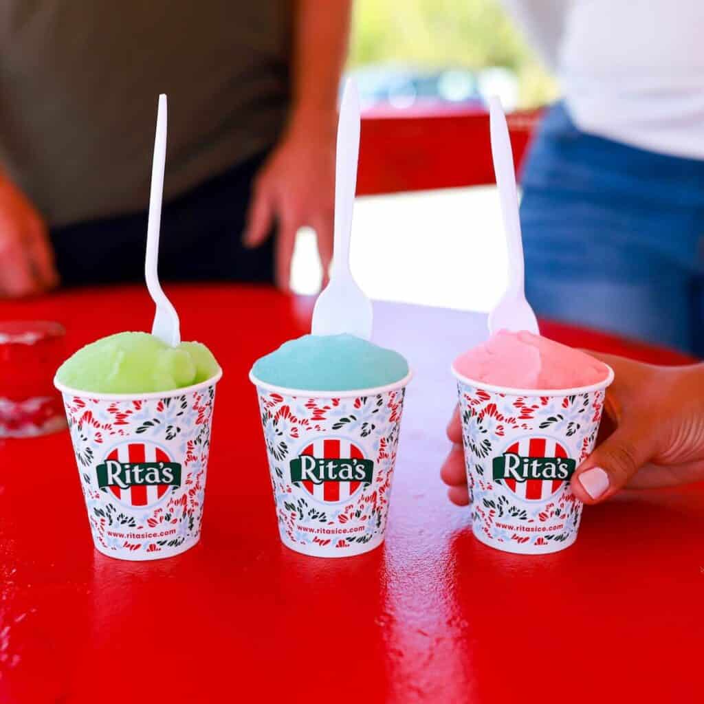 three cups of Italian Ice on a red table