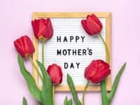 Felt board with text Happy Mother's day, red tulips bouquet on pink backround greeting holiday card Flat lay Top view.
