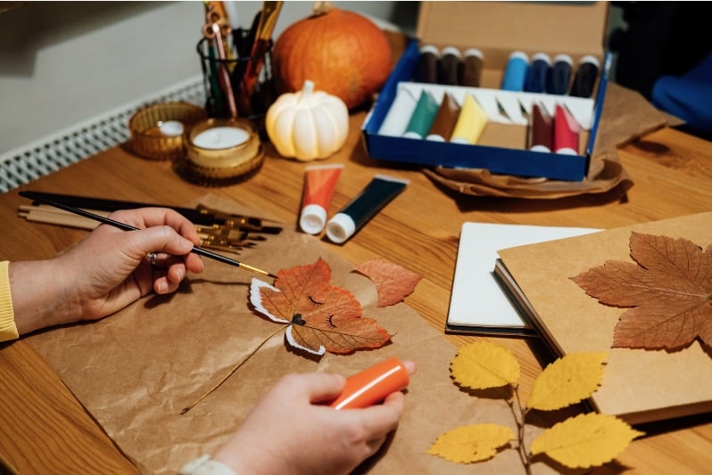 person painting a leaf to make a print