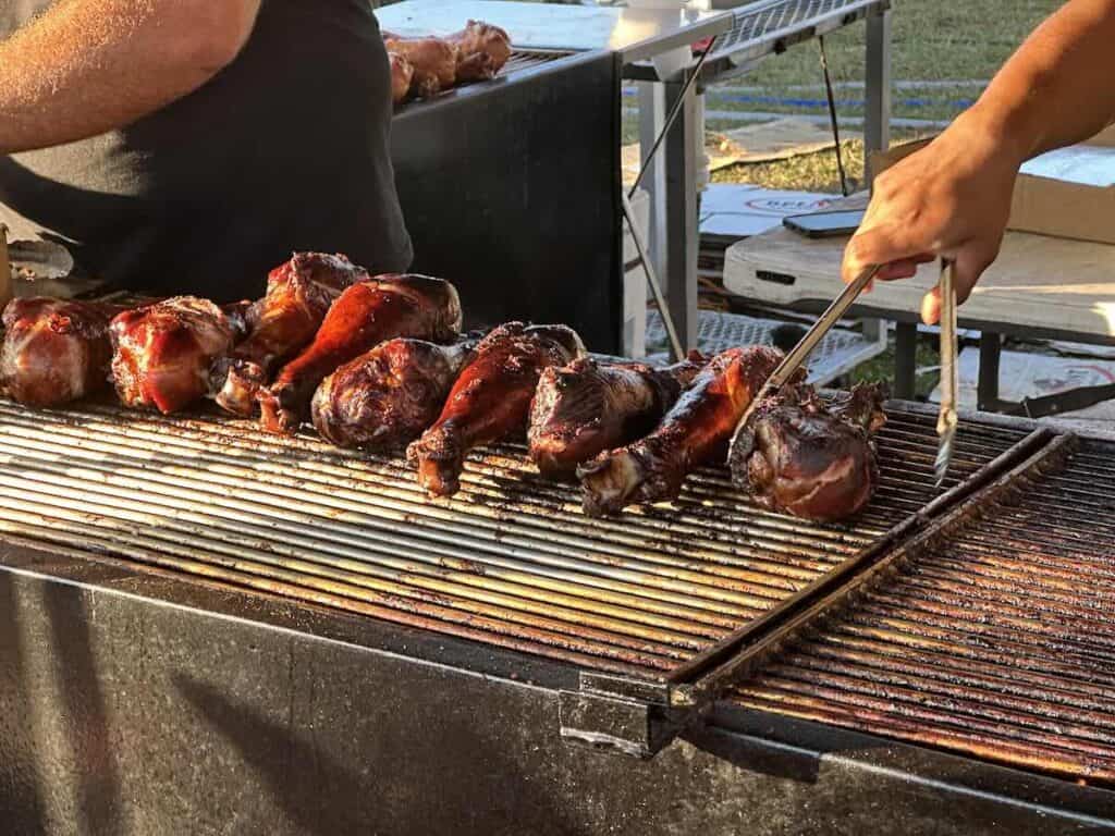 Turkey legs cooking on a grill at Queen Charlotte Fair
