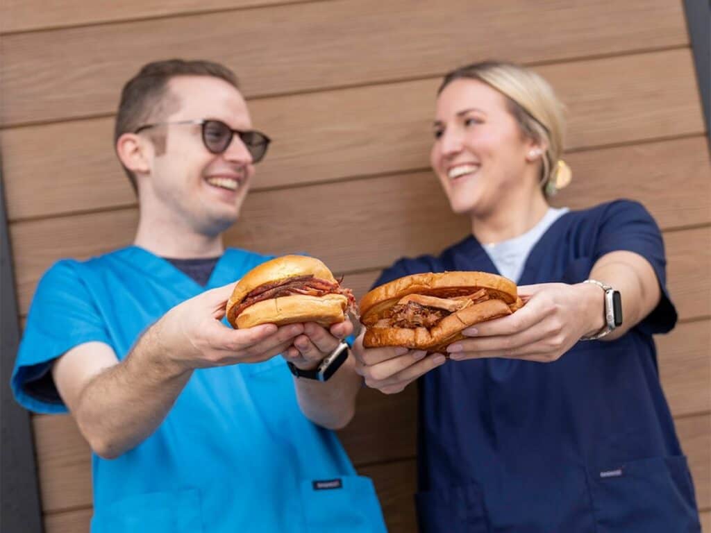 two nurses holding BBQ sandwiches