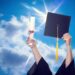 graduation cap and diploma in air