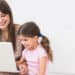 mother and daughter using laptop