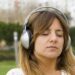 woman relaxing and listening music in a park
