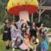 A group of women in costumes pose for a photo with a giant mushroom