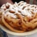 funnel cake on plate with powdered sugar