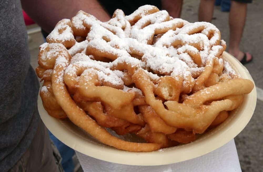 funnel cake on plate with powdered sugar
