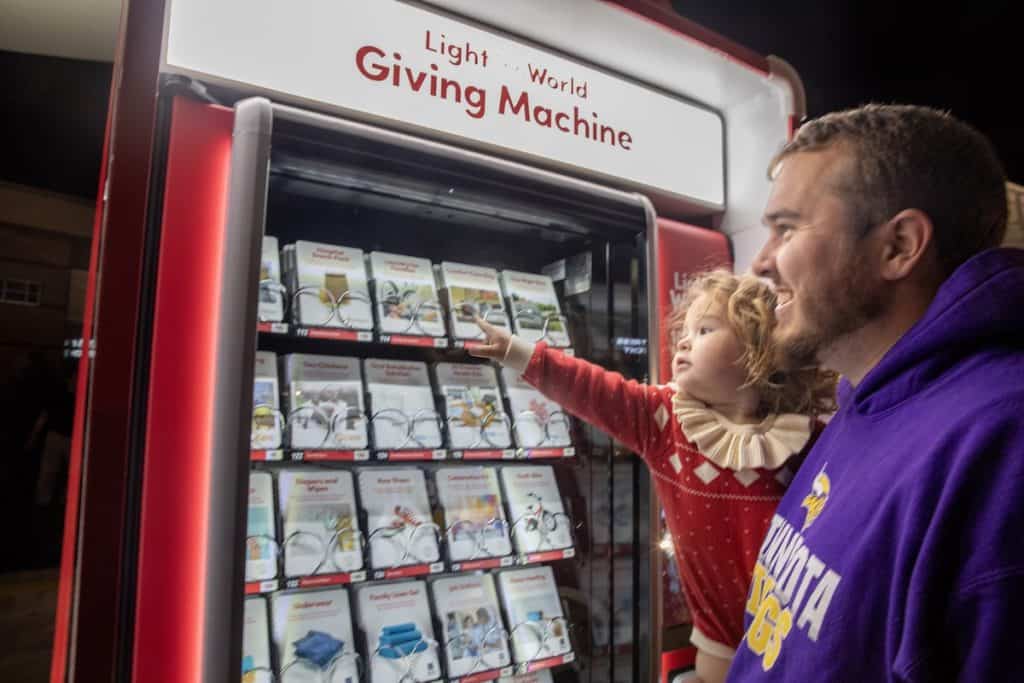 Man and child looking at items in the Giving Machine