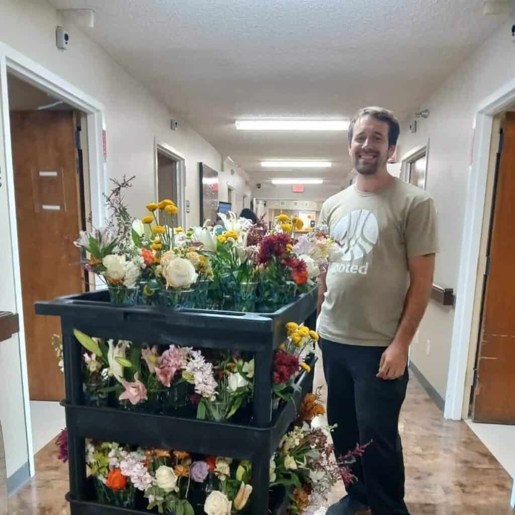Man with cart of flower arrangements