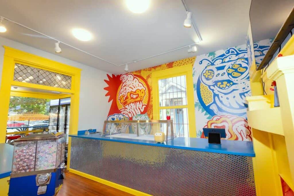 A colorful ice cream shop with a colorful mural on the wall